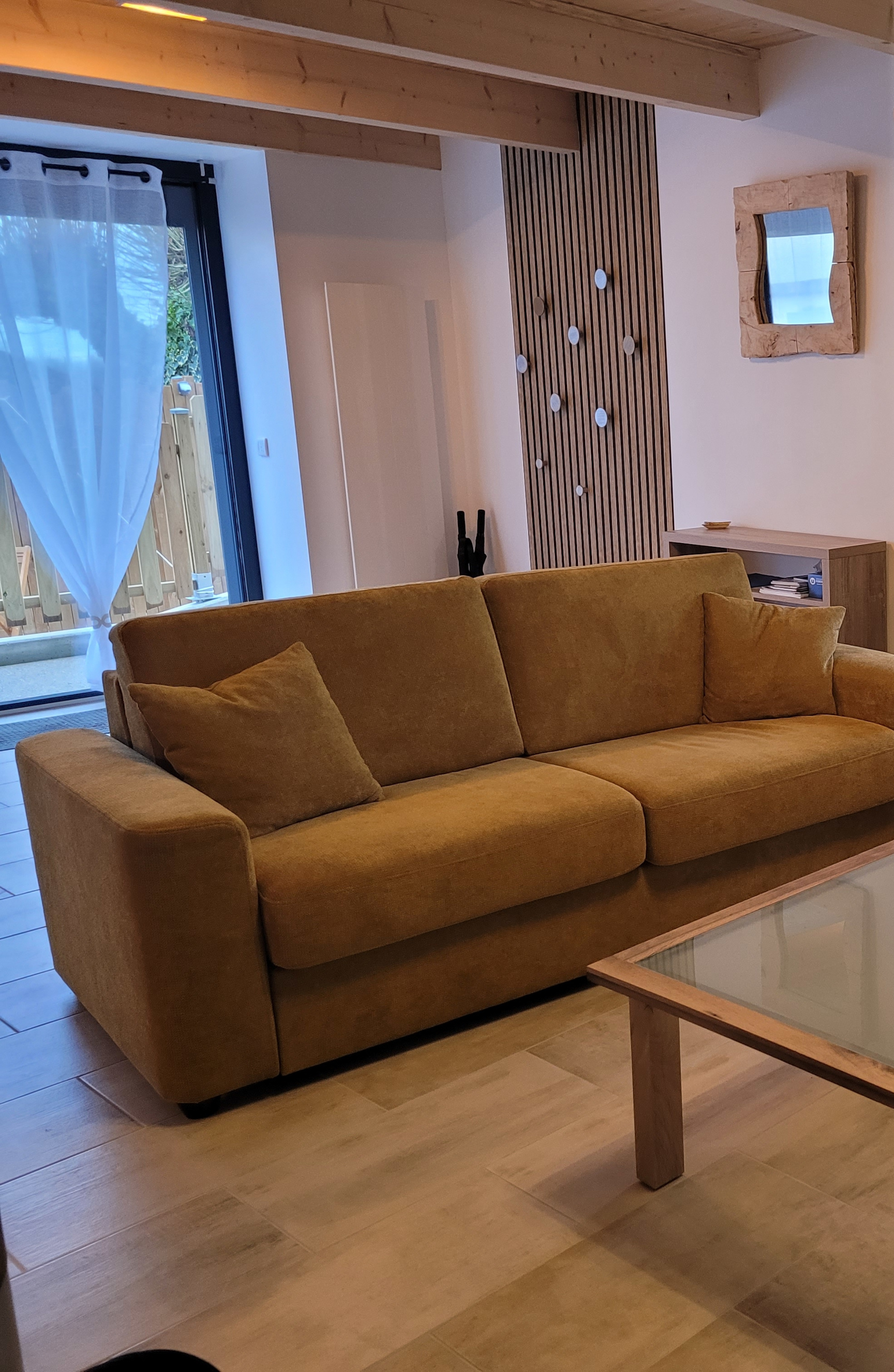 Salon gauche du gîte avec canapé et décoration